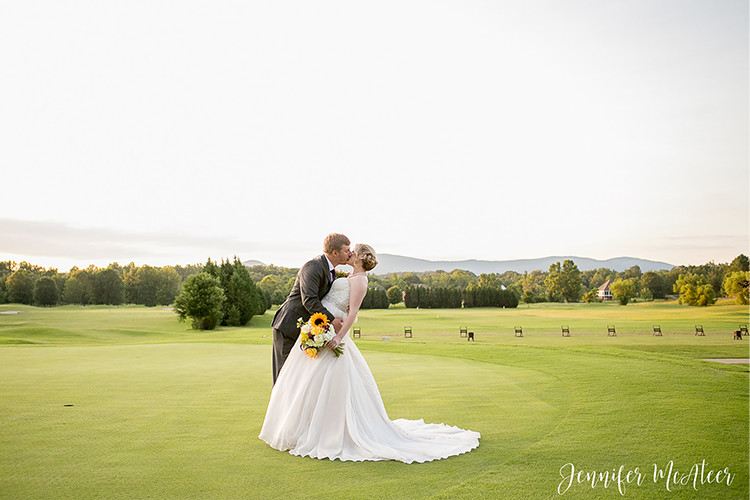 bride and groom sharing kiss on course green